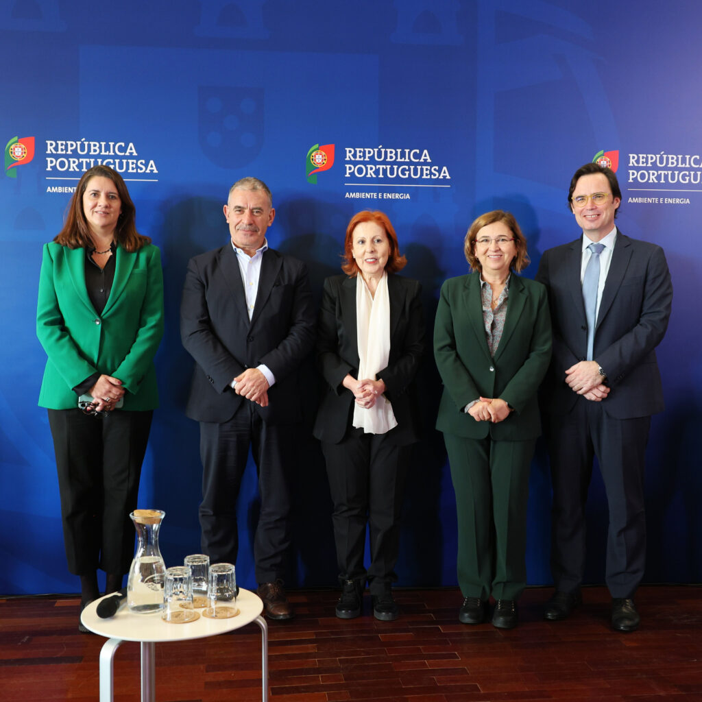 Cinco pessoas estão lado a lado em frente a um fundo azul com o logótipo da República Portuguesa — Ambiente e Energia. O grupo é composto por três mulheres e dois homens, todos vestidos formalmente e a sorrir.