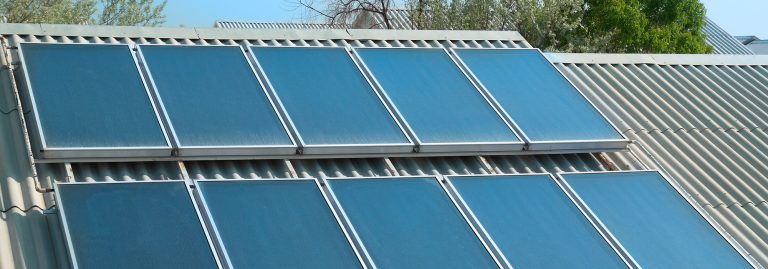Grande plano painéis solares térmicos dipostos num telhado em duas filas