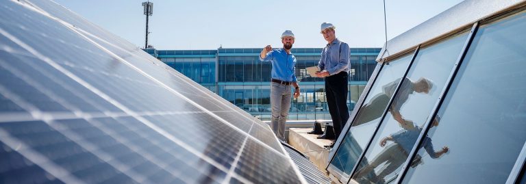 técnicos numa cobertura de um edifício com painéis fotovoltaicos