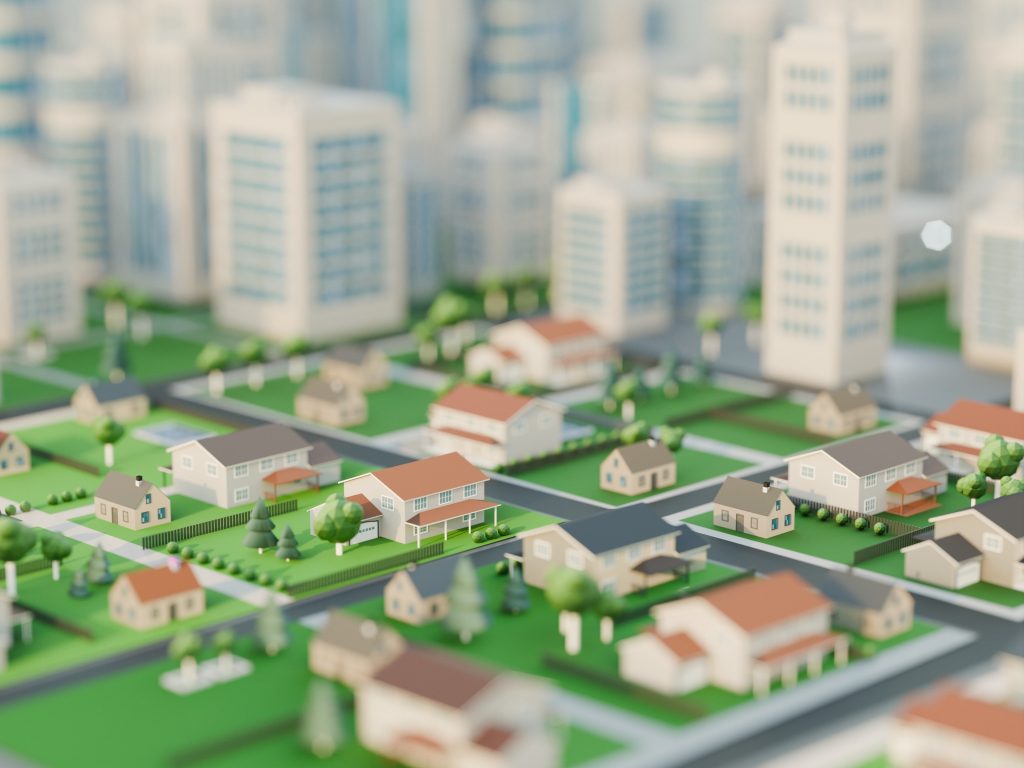 Ilustração de uma cidade em miniatura, com casas pequenas e ruas verdes em primeiro plano e edifícios altos desfocados ao fundo.